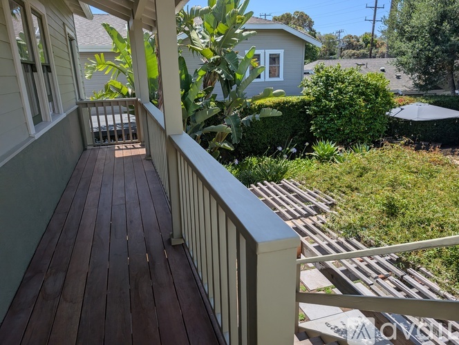 A wooden deck with a railing and a view of a backyard.