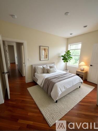 A bedroom with a large bed and a window.
