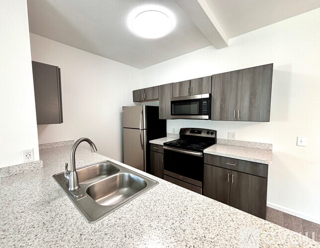 A kitchen with a sink, stove, and refrigerator.