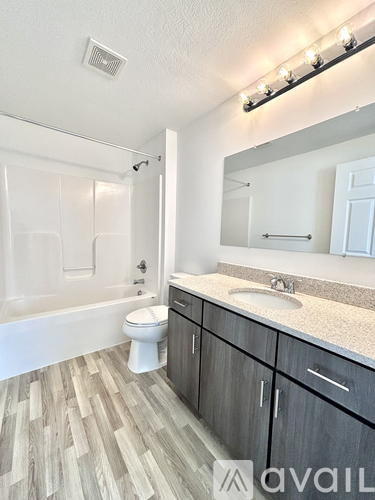 A bathroom with a wooden floor and a white toilet.