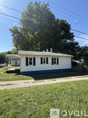 A white house with a blue stripe and a brown roof.