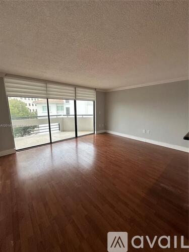 A room with wooden flooring and sliding glass doors.