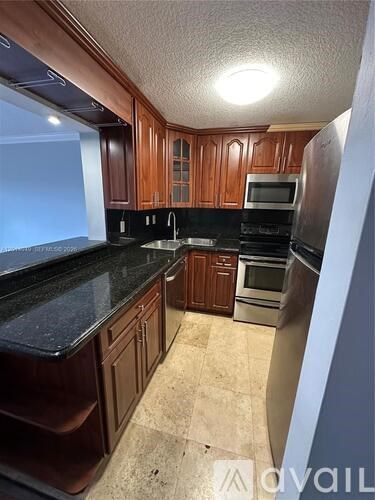 A kitchen with wooden cabinets and black countertops.