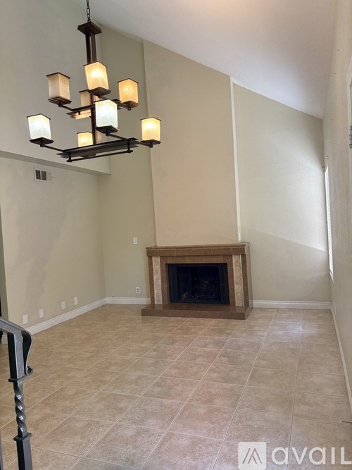 A living room with a fireplace and a chandelier.