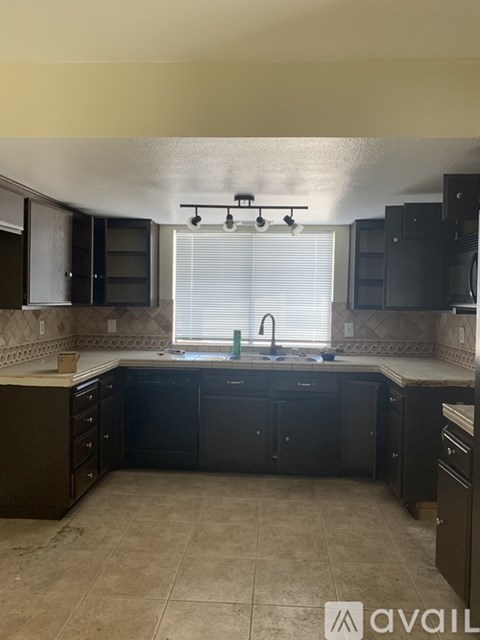 A kitchen with black cabinets and a tiled backsplash.