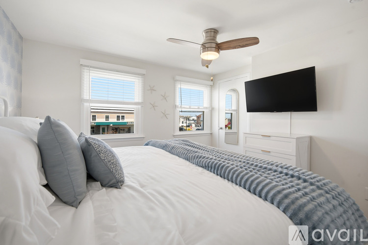 A bedroom with a large bed and a ceiling fan.