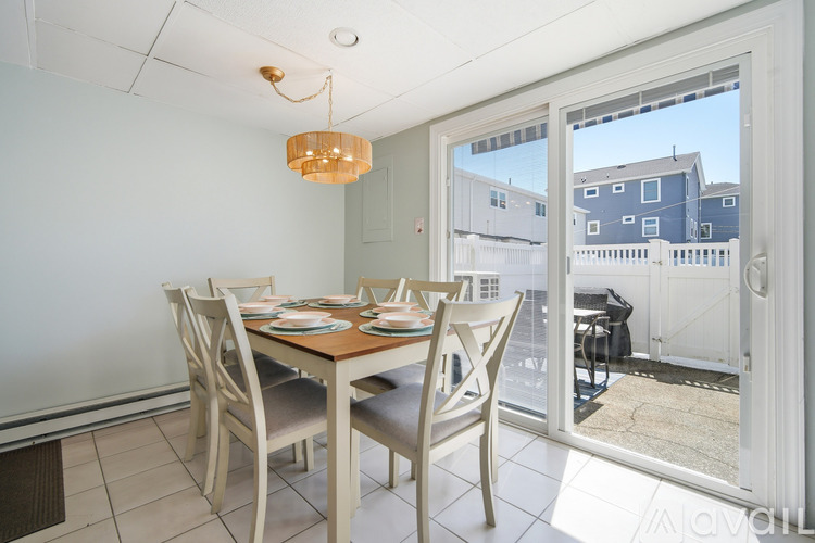 A dining room with a table set for four and a view of the outside.