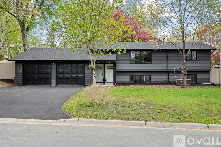 A two-story house with a garage and a driveway.