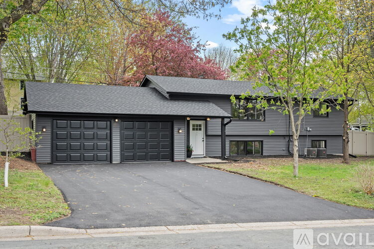 A house with a black garage door is for sale.