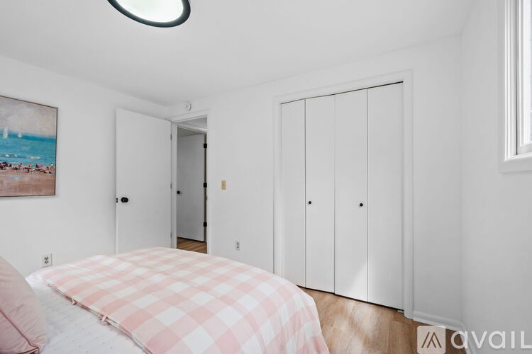 A bedroom with a bed and a painting on the wall.