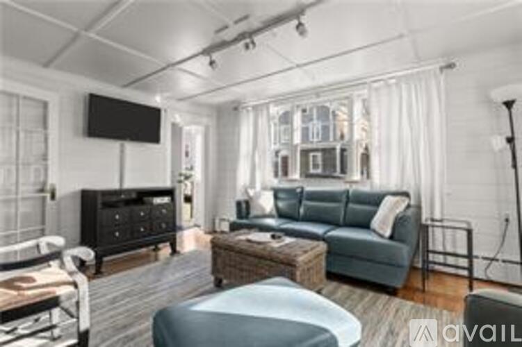 A living room with a grey sofa and a black cabinet.