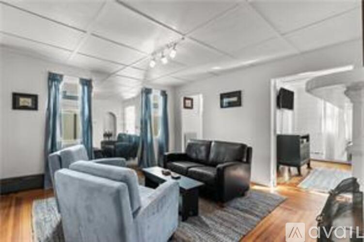 A living room with a grey sofa and a black coffee table.