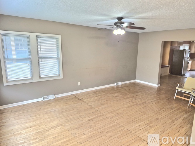 A room with wooden flooring and a ceiling fan.
