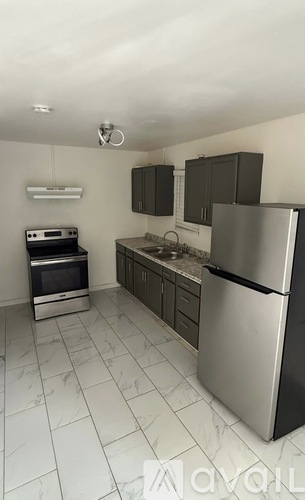 A kitchen with a refrigerator, oven, and microwave.