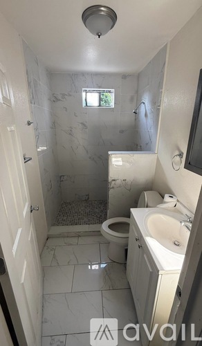 A bathroom with a toilet, sink, and shower.