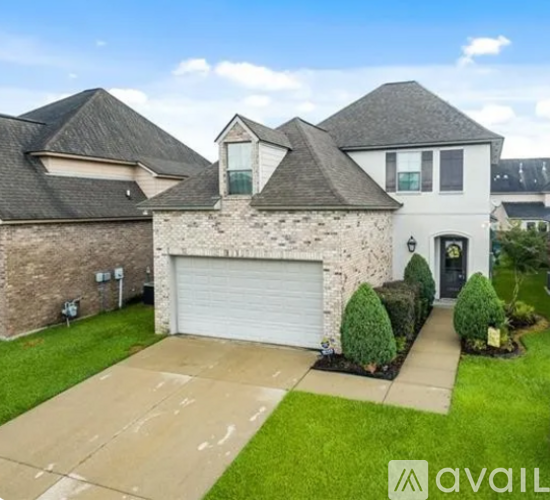 A house with a garage and a driveway in front.