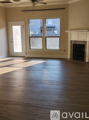 A living room with a fireplace and a fan on the ceiling.