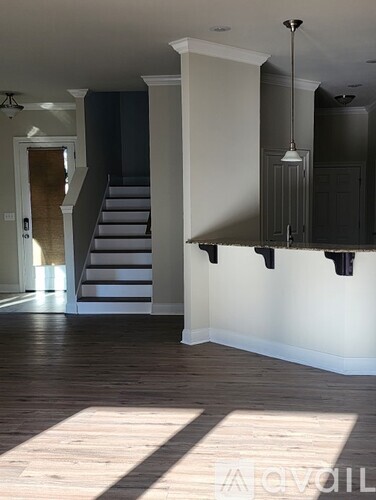 A room with a staircase and a cabinet.