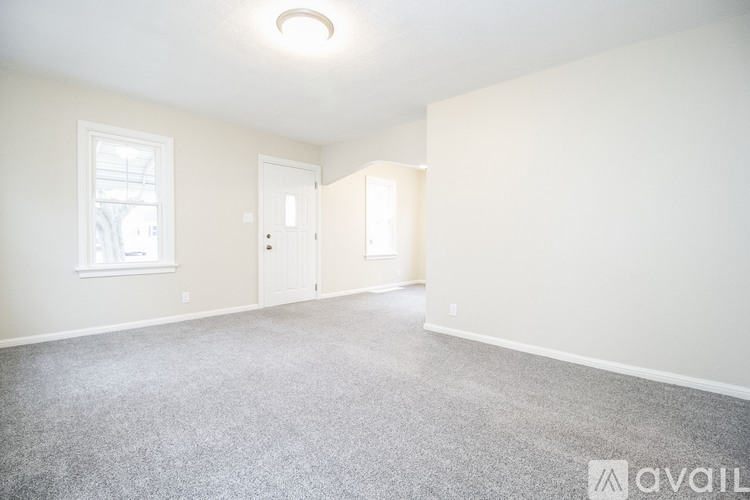 A spacious room with a carpeted floor and two doors.