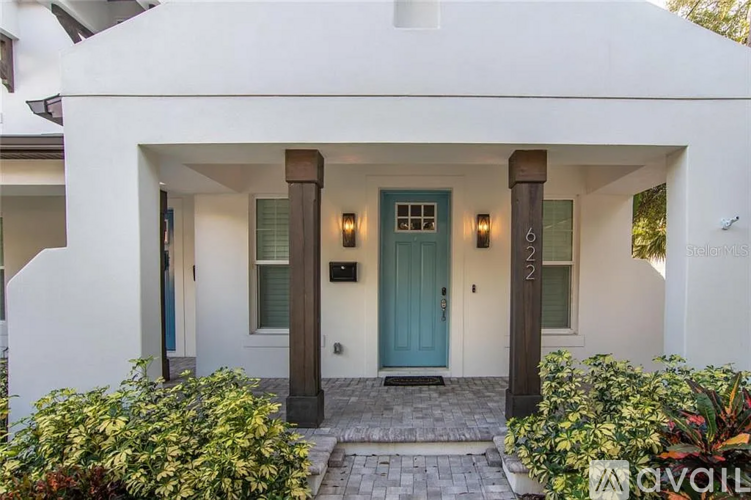 A white house with a blue door and a sign that says "available".