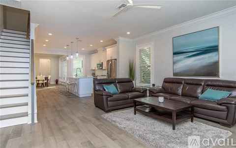 A living room with a brown leather couch and a painting on the wall.