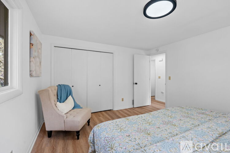 A bedroom with a bed, chair, and wardrobe.