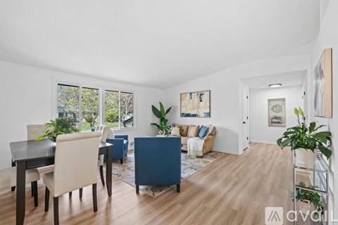 A living room with a dining table and chairs.
