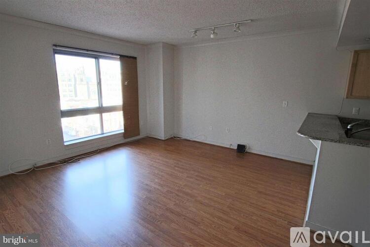 A room with wooden floors and a window with sunlight coming through.