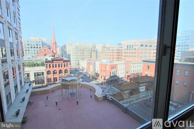 A view from a window of a courtyard with a gazebo and people walking around.