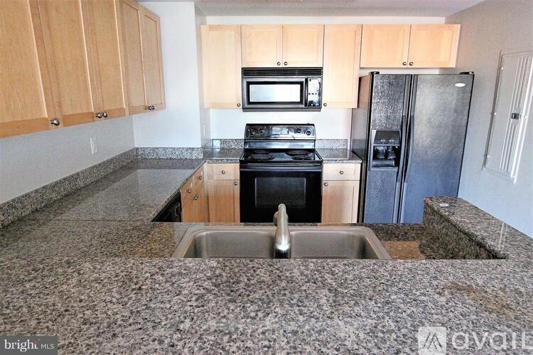 A kitchen with a granite counter top and a sink.