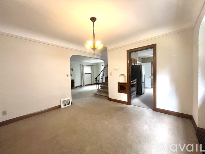 A spacious room with a staircase leading to another floor.