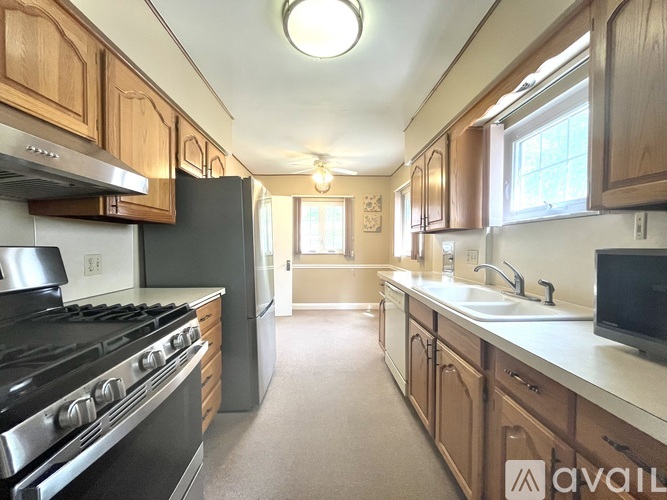 A kitchen with wooden cabinets and a black stove top oven.