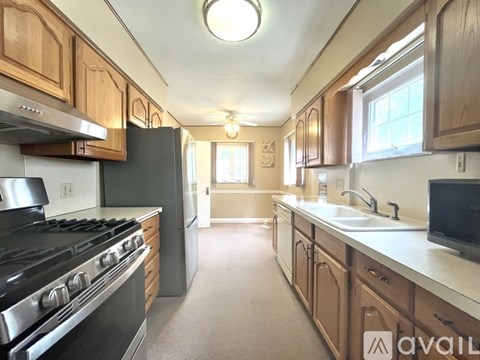 A kitchen with wooden cabinets and a black stove top oven.