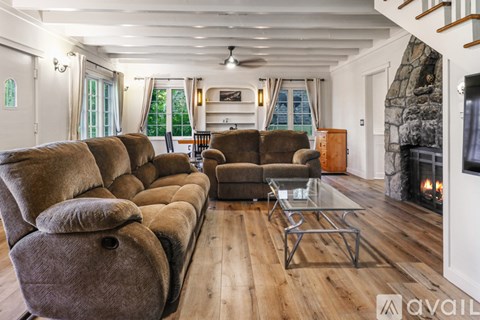 A living room with a row of brown couches and a glass coffee table.