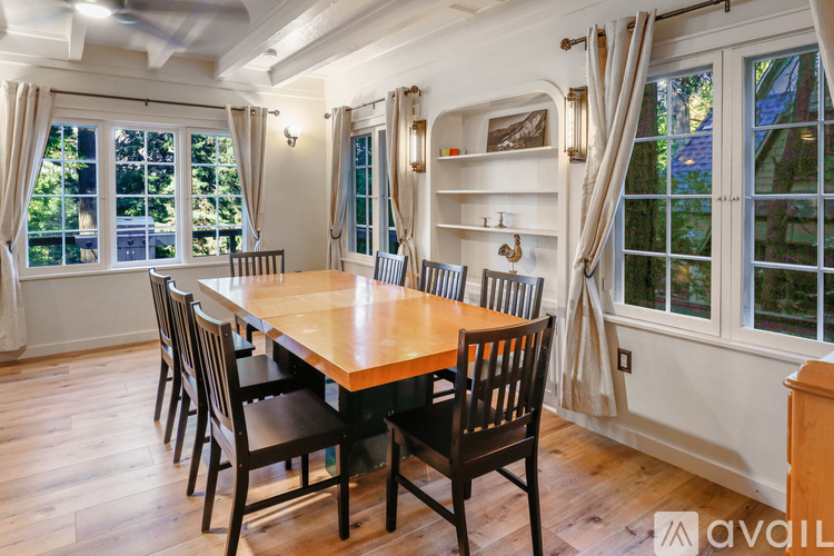 A dining room with a wooden table and chairs.