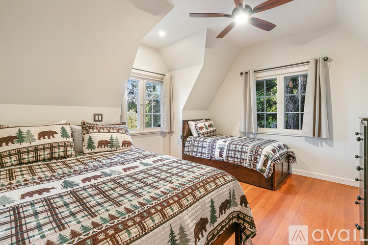 A bedroom with two beds and a ceiling fan.
