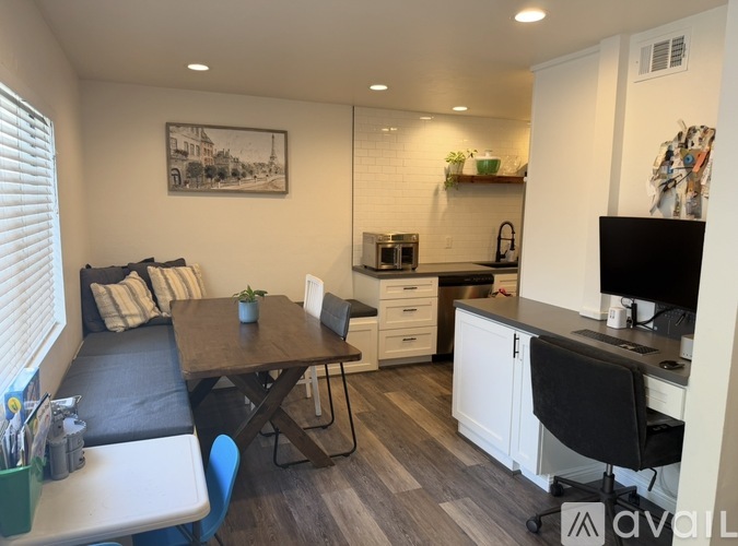 A modern kitchen with a black chair and a wooden table.