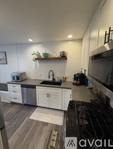 A kitchen with white cabinets and a black stove top.