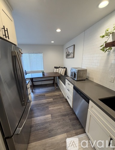A kitchen with a refrigerator, dishwasher, and oven.