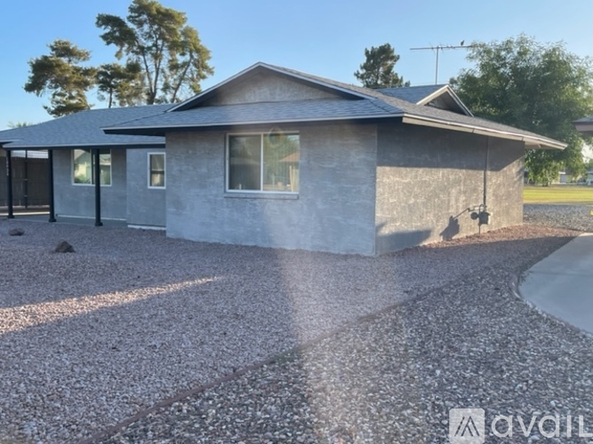 A house with a grey roof and a gravel driveway.
