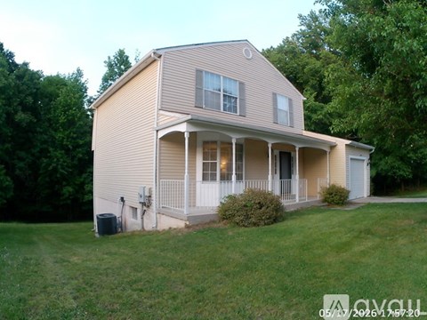 A house with a covered porch and a garage door.