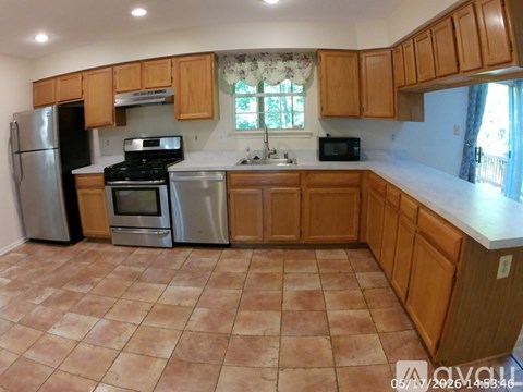 A kitchen with wooden cabinets and tile flooring.