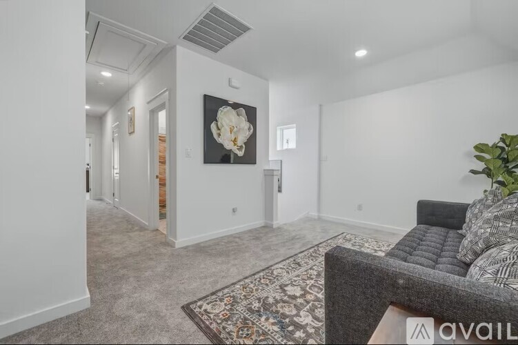 A living room with a grey couch and a rug.