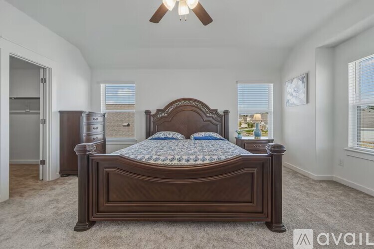 A bedroom with a large bed and a ceiling fan.