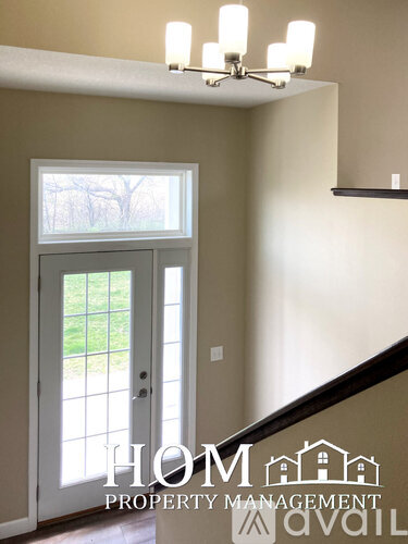 A white door with a glass window is in a room with a chandelier.