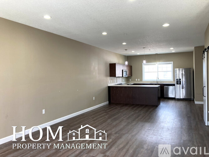 A spacious room with a kitchenette and a refrigerator, available for rent.