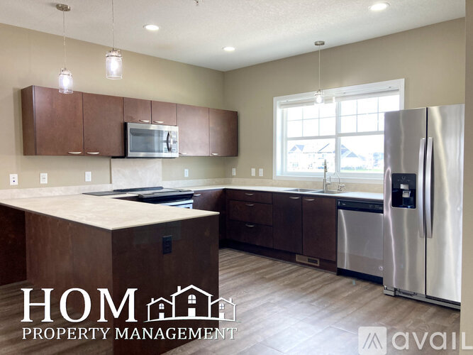 A kitchen with brown cabinets and a white fridge is available for rent.