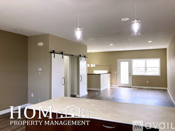 A spacious, empty room with a sliding glass door leading to a balcony.