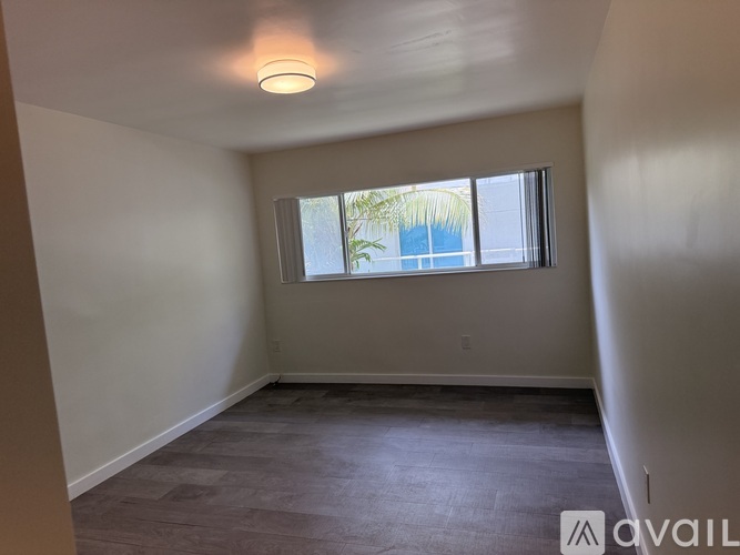 Empty room with a window and a ceiling light.
