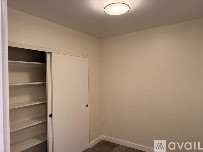 A white closet with a door and shelves.